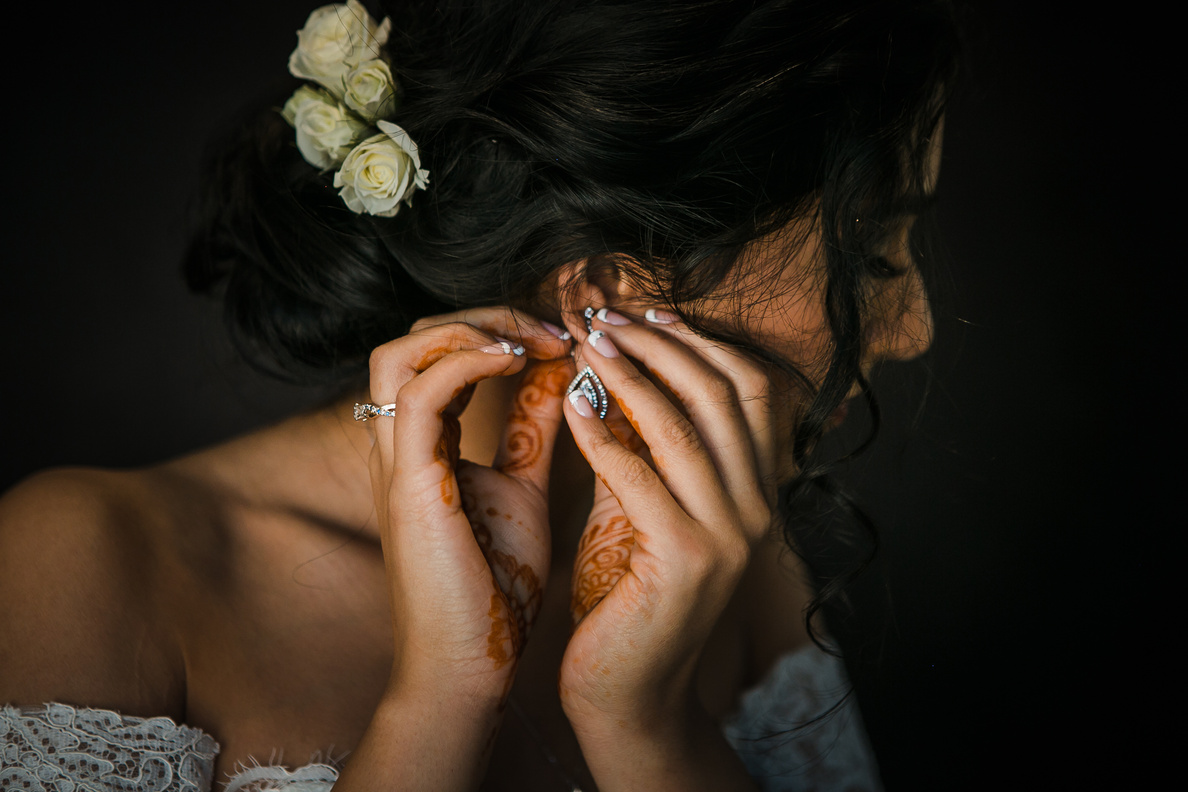 Indian woman with mehendi wearing earrings for wedding