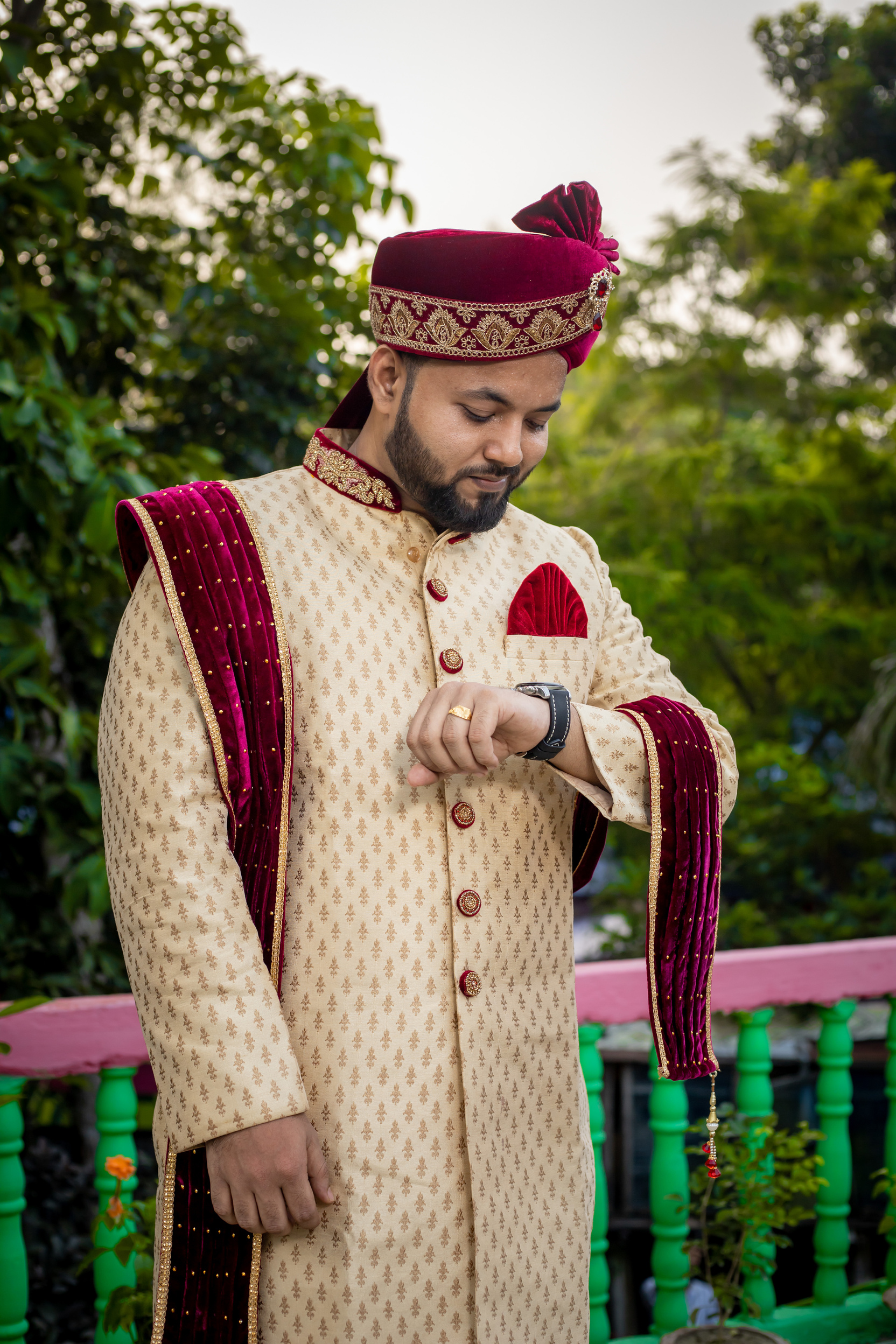 Groom in Traditional Clothing Looking at the Time